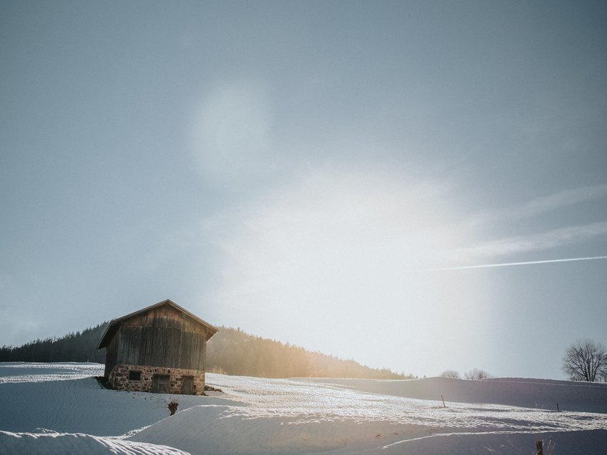 A winter holiday on the Alpe di Suisi/Seiser Alm Wooden house on snowy field on a sunny winter day
