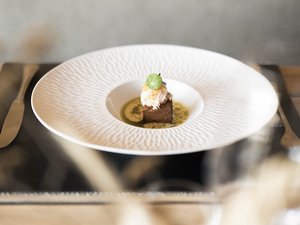 Puro gusto nel nostro ristorante a Fiè allo Sciliar Piccolo piatto gourmet su piatto bianco con salsa verde