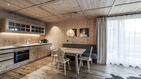 Immagini che emozionano: appartamenti Presulis a Fiè Piccola cucina moderna con zona pranzo in legno e sedie