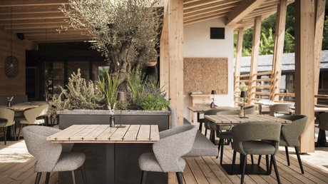 Immagini che emozionano: appartamenti Presulis a Fiè Accogliente terrazza esterna con tavoli in legno e sedie imbottite di design moderno