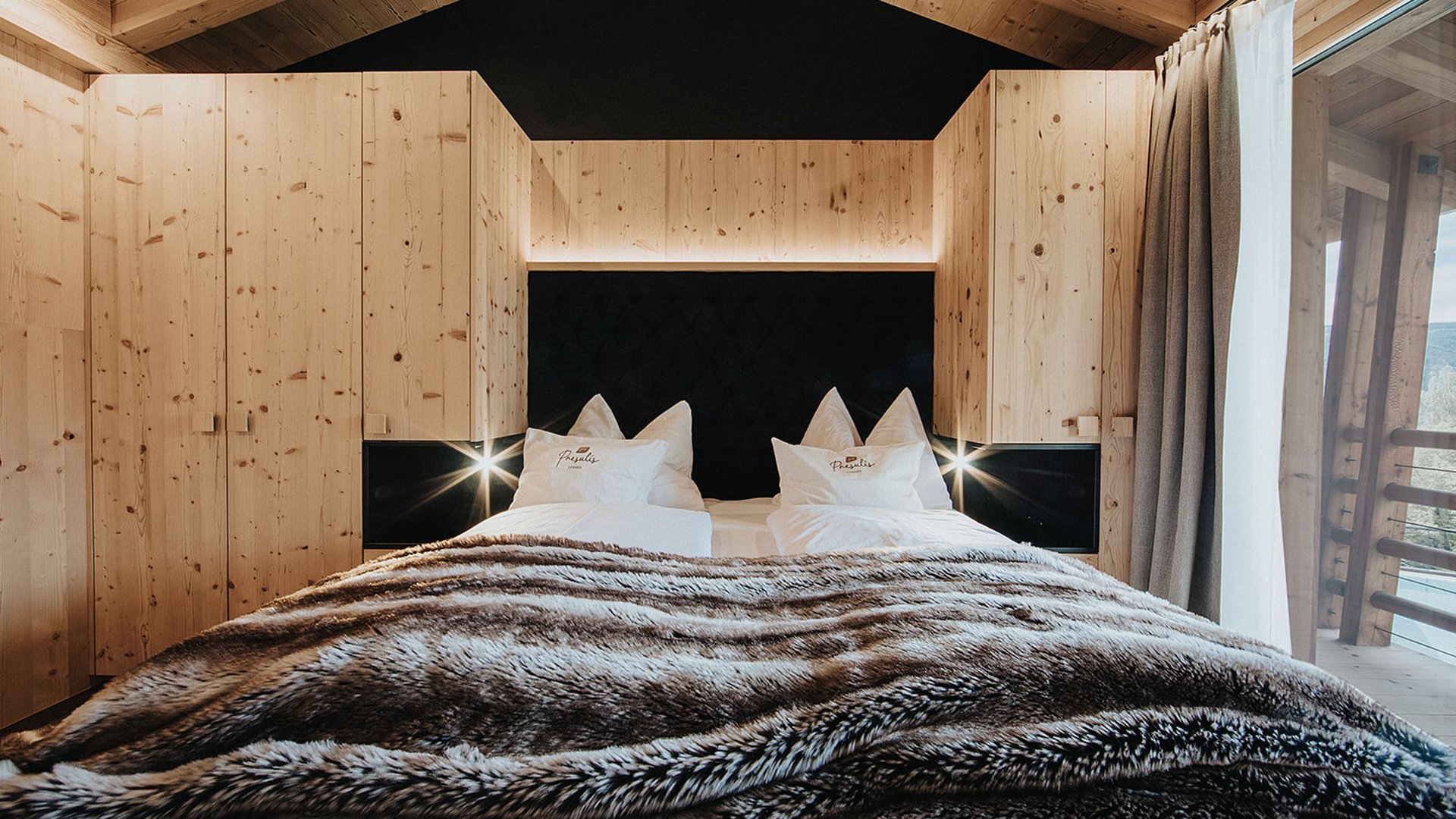 A luxurious stay in your apartment in Völs am Schlern Cozy bedroom with wooden walls and bed with furry blanket