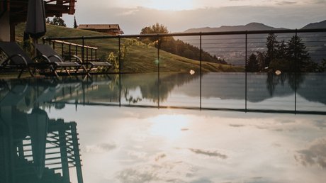 Immagini che emozionano: appartamenti Presulis a Fiè Tramonto su piscina con vista su colline verdi e montagne