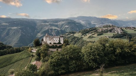 Heartfelt snapshots: the Presulis apartments in Völs Castle on forested hill with mountains and village in the background