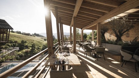 Immagini che emozionano: appartamenti Presulis a Fiè Terrazza coperta in legno di un ristorante con vista sulle colline verdi