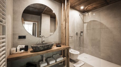 Immagini che emozionano: appartamenti Presulis a Fiè Bagno moderno con specchio rotondo e dettagli in legno
