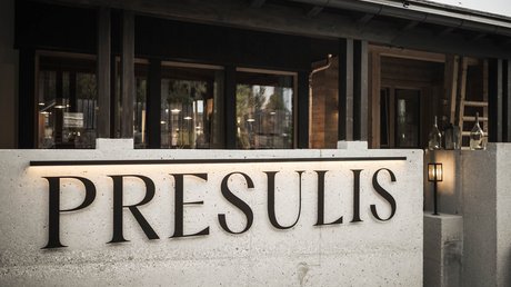 Immagini che emozionano: appartamenti Presulis a Fiè Insegna illuminata PRESULIS su muro di cemento davanti a edificio moderno