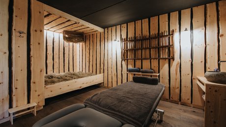 Immagini che emozionano: appartamenti Presulis a Fiè Stanza massaggi accogliente con pareti in legno e lettino comodo