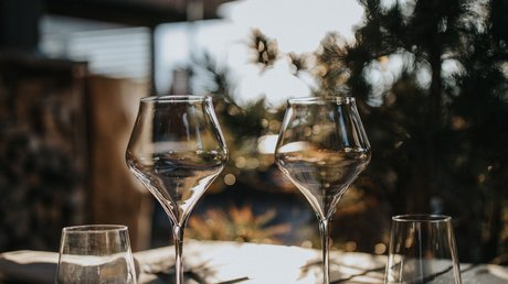 Immagini che emozionano: appartamenti Presulis a Fiè Bicchieri vuoti su un tavolo di legno al sole all'aperto