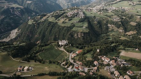 Heartfelt snapshots: the Presulis apartments in Völs Aerial view of a mountain village with a castle and green valleys