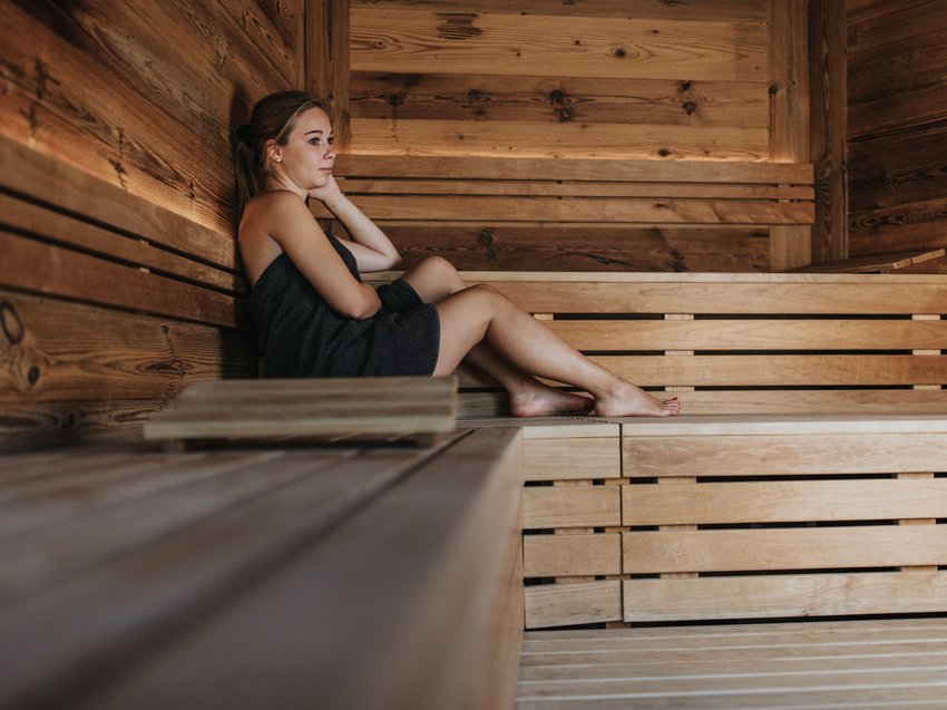 Ihre Luxus-Ferienwohnung in Völs am Schlern mit Pool Frau entspannt in einem Holzbanksauna
