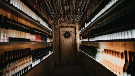 Immagini che emozionano: appartamenti Presulis a Fiè Stanza stretta per conservare vino con file di bottiglie sui lati