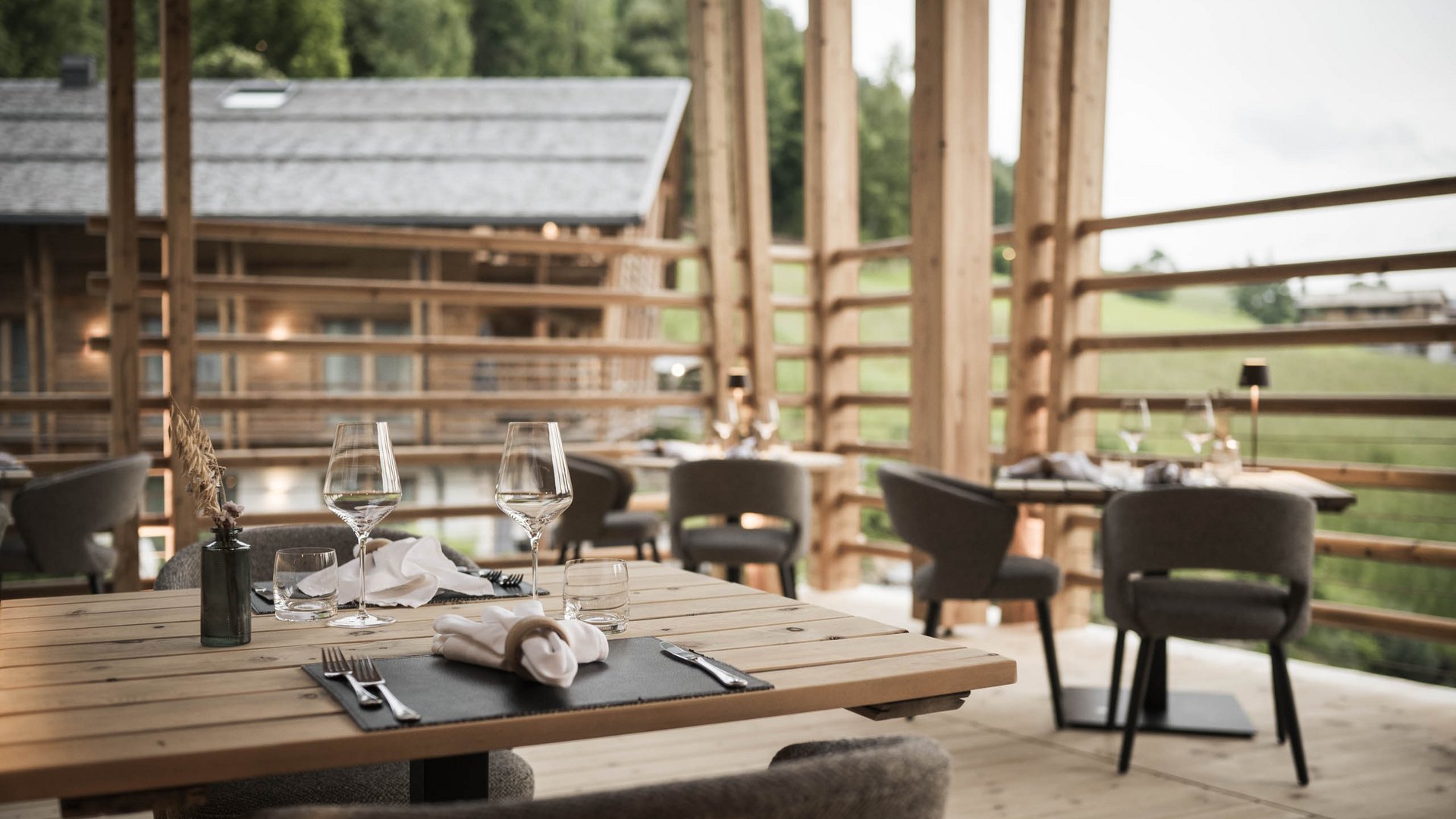 Presulis: Ihre Luxus-Ferienwohnung in Völs am Schlern Elegantes Restaurant mit Holztischen und Blick ins Grüne