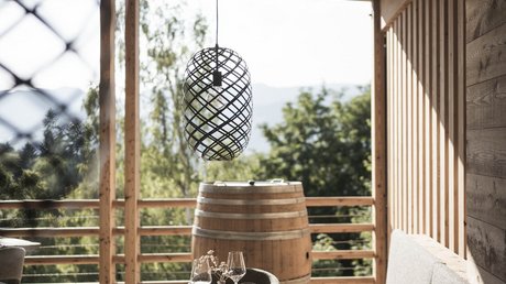 Immagini che emozionano: appartamenti Presulis a Fiè Area pranzo accogliente su terrazza in legno con vista sul verde e botti di vino