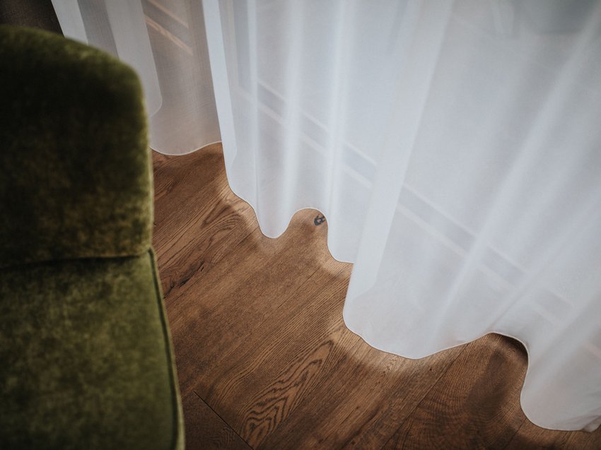 Die Stille genießen: Ihre Unterkunft in Völs am Schlern Weißer Vorhang über Holzboden neben grünem Möbelstück