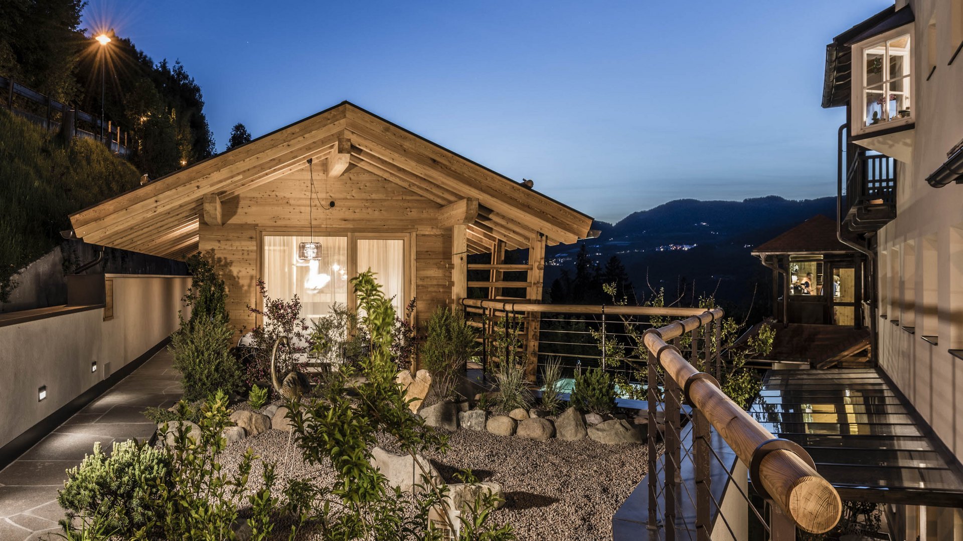Presulis: Ihre Luxus-Ferienwohnung in Völs am Schlern Beleuchtetes Holzhaus mit Garten und Bergblick bei Dämmerung