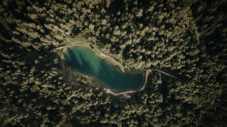 Heartfelt snapshots: the Presulis apartments in Völs Aerial view of a small lake surrounded by dense forest