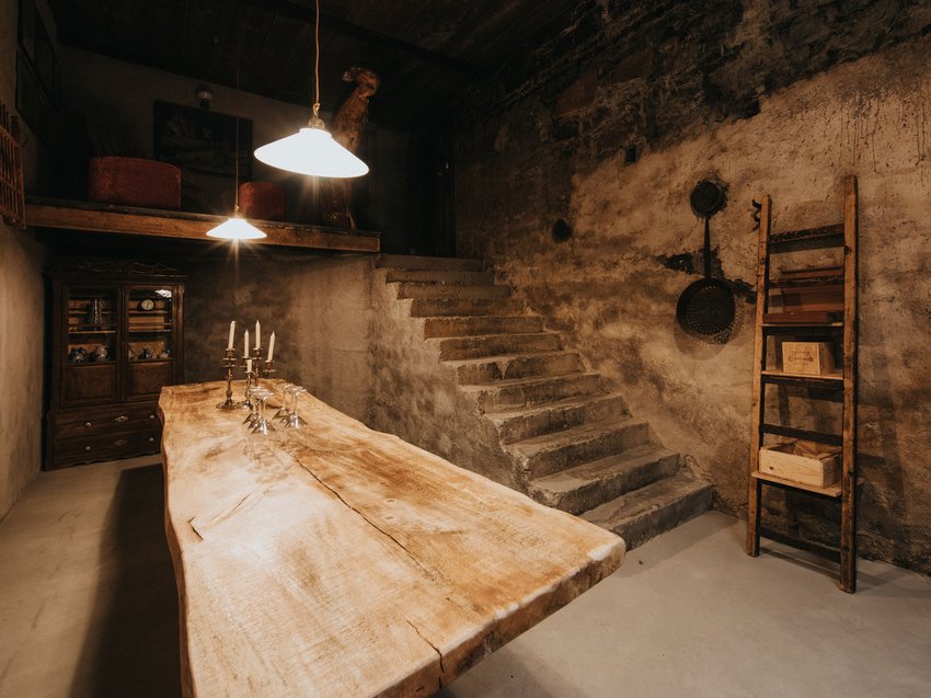 Presulis: degustazioni di vini in Alto Adige Locale rustico con scala in legno, grande tavolo in legno e mobili antichi