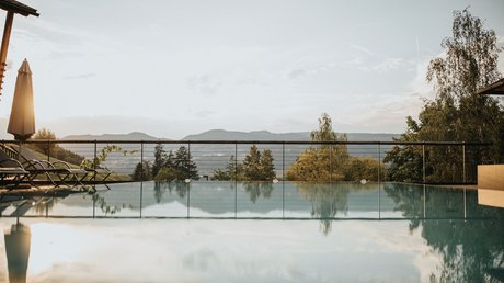 Immagini che emozionano: appartamenti Presulis a Fiè Piscina a sfioro con vista sulle montagne al tramonto