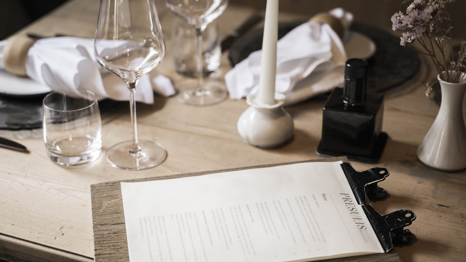 Pure indulgence in our restaurant in Völs am Schlern Elegant dining table set with wine glasses and menu