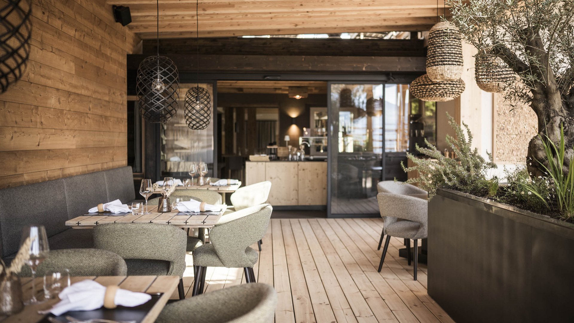 Accogliente terrazza in legno con tavoli apparecchiati e sedie moderne in un ristorante